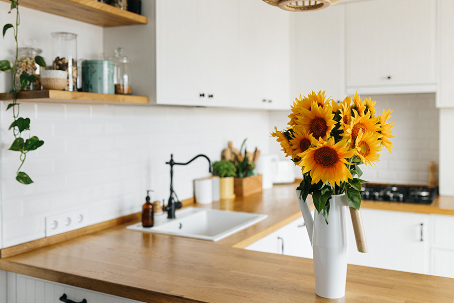 A small modern kitchen with sunflowers cleaned by a professional maid cleaning service in Decatur, IL.